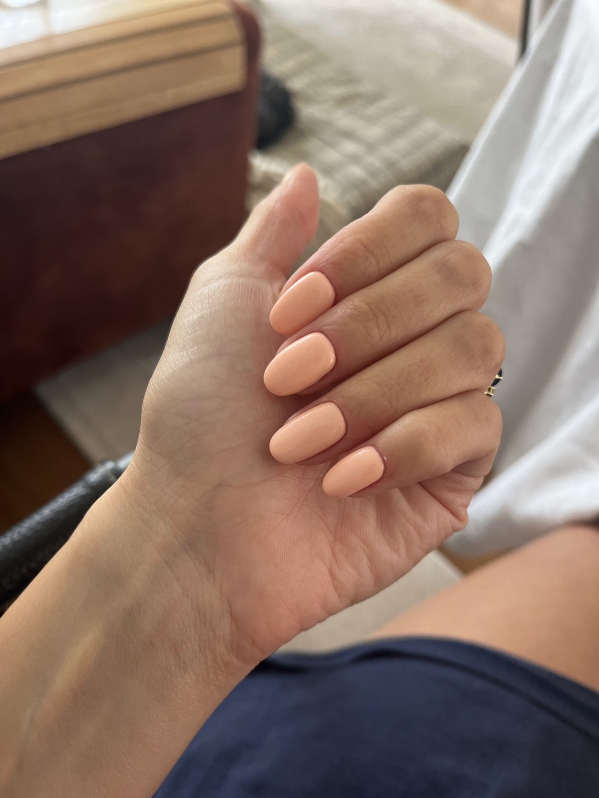 Hand met perzikkleurige, ronde nagels